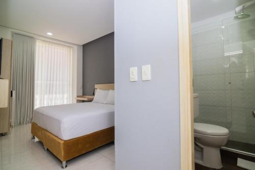 a bedroom with a bed and a toilet at Hotel Gallery Cartagena in Cartagena de Indias