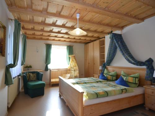 ドラクセルスリートにあるFerienwohnung im Bayerischen Wald mit Saunaのベッドルーム1室(ベッド1台、緑の椅子付)