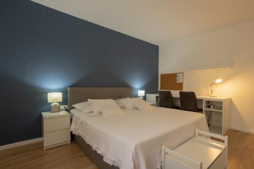 a bedroom with a large white bed with two chairs at Apartman Citromelo in Split