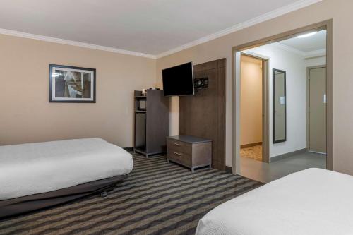 a hotel room with two beds and a flat screen tv at Best Western Silicon Valley Inn in Sunnyvale