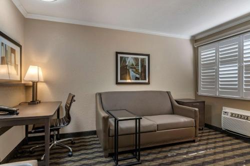 a living room with a couch and a desk and a chair at Best Western Silicon Valley Inn in Sunnyvale