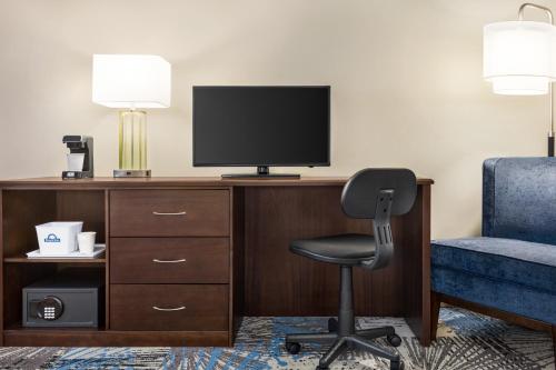 a room with a desk with a chair and a television at Days Inn by Wyndham Philadelphia Convention Center in Philadelphia