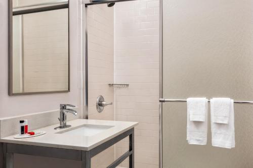 a bathroom with a sink, mirror and towel rack at Days Inn by Wyndham Philadelphia Convention Center in Philadelphia