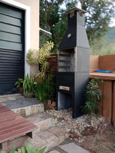 a outdoor oven in a garden next to a house at Solar Lisboa 100 m da Praia com vista para mar in Balneário Camboriú