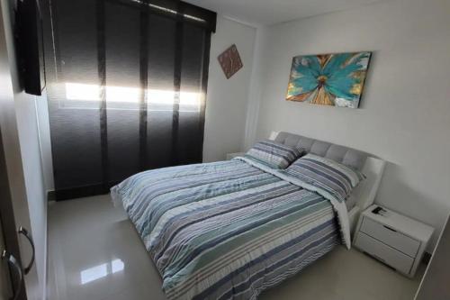 Apartamento con Vista al Mar en Bocagrande Cartagena في كارتاهينا دي اندياس: غرفة نوم صغيرة بها سرير ونافذة
