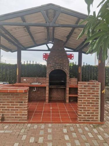 a brick patio with a pavilion with a fireplace at Agradable casa con piscina en tierra caliente in Flandes