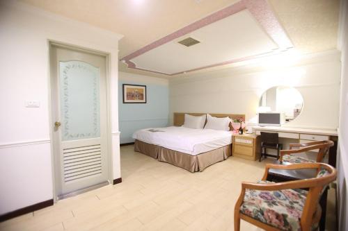 a bedroom with a bed and a desk and a chair at 享平方文旅 in Douliu