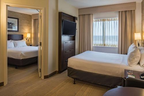 a hotel room with two beds and a television at Sonesta Chicago O'Hare Airport Rosemont in Rosemont