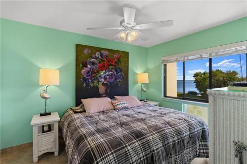 1 dormitorio con 1 cama con una pintura floral en la pared en Wander Residence Condo near Fort DeSoto, en Tierra Verde