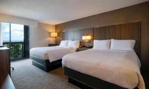 a hotel room with two beds and a large window at Holiday Inn Nashville - Vanderbilt - Dwtn by IHG in Nashville