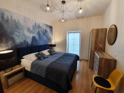 a bedroom with a bed and a yellow chair at Apartament z Ogrodem in Stanisławów Pierwszy