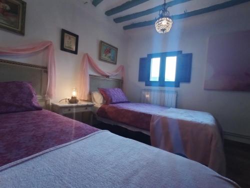 a bedroom with two beds and a chandelier at Riojania Heredad in Santa Eulalia Bajera