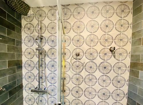 a shower in a bathroom with a tile wall at SUITE SORPRESA VuT LA TABERNA in Arenas de San Pedro