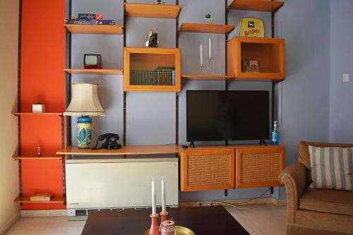 a living room with an entertainment center with a television at Olive - HappyHostGr - Downtown Apartment in Volos