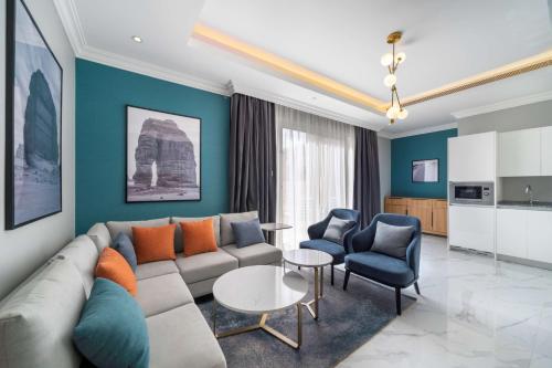 a living room with a couch and a table and chairs at Radisson Hotel Riyadh Airport in Riyadh