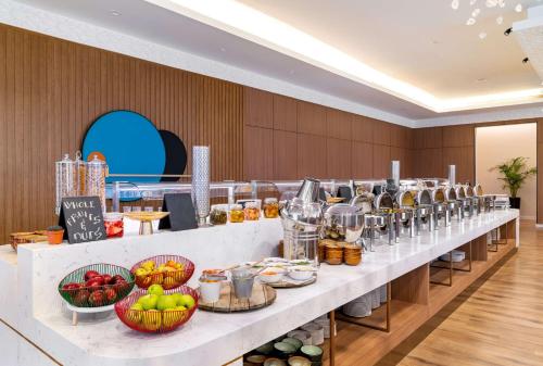 a buffet line with bowls of fruit and other food at Radisson Hotel Riyadh Airport in Riyadh