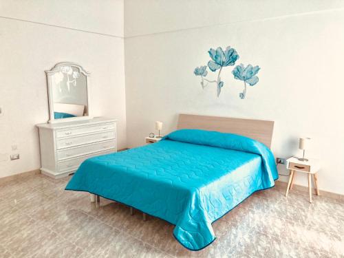 una camera con letto blu e specchio di Marì casa vacanze a Noci