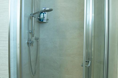 ducha con puerta de cristal y cabezal de ducha en Casa di Giovanni, en Golfo Aranci
