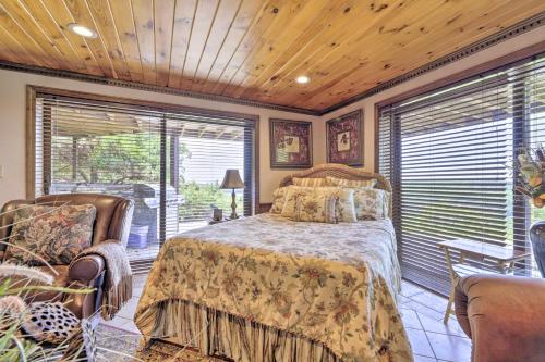 een slaapkamer met een bed, een stoel en ramen bij Cozy Studio Indoor Hot Tub and Inground Pool Access in Uncasville