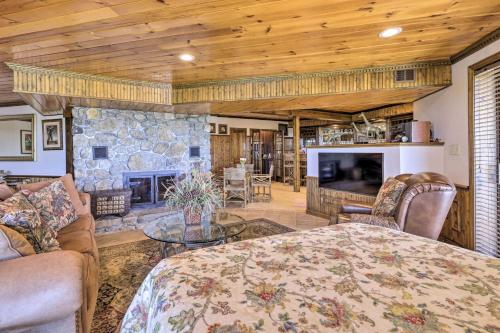 a living room with a stone fireplace and a table at Cozy Studio Indoor Hot Tub and Inground Pool Access in Uncasville