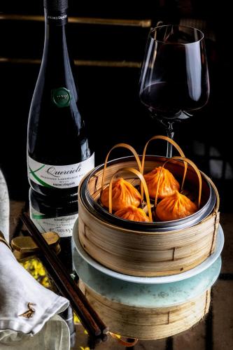 a bowl of food next to a bottle of wine at Paradox Vancouver in Vancouver