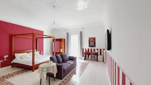 a living room with a couch and a bed at D-Home Ortigia in Siracusa