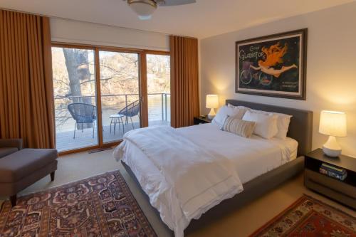 a bedroom with a large white bed and a balcony at Chase Creek Retreat in Annapolis