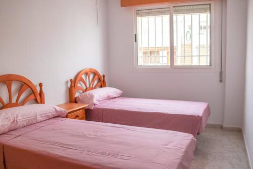 2 camas en una habitación con ventana en LA CASITA DEL CABO en Cabo de Gata