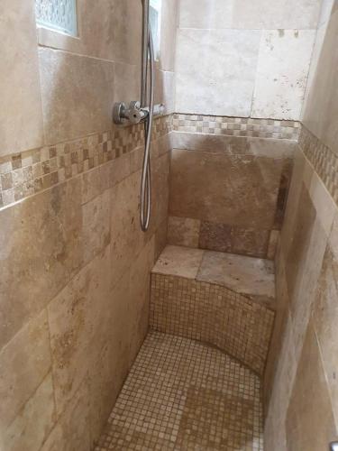 une salle de bain avec une douche avec un banc dedans dans l'établissement Dépendance et chambre avec piscine et jardin privés sans vis-à-vis, à Montarnaud