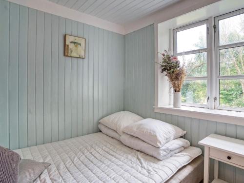 a bed in a corner of a room with a window at 6 person holiday home in Melby-By Traum in Melby