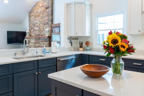 une cuisine avec des armoires bleues et un vase de fleurs sur un comptoir dans l'établissement Thomas Point Tranquility, à Annapolis