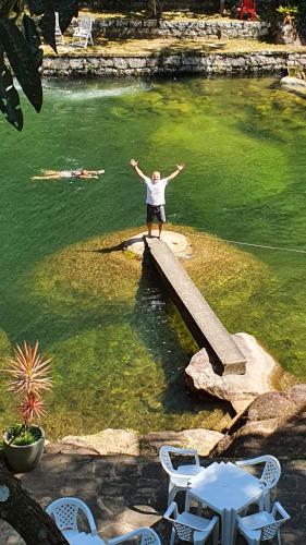 a man standing on a dock in a body of water at Estalagem do Rancho in Itatiaia