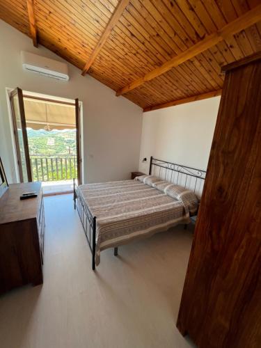 a bedroom with a bed and a large window at Agriturismo Baccanale in Prignano Cilento