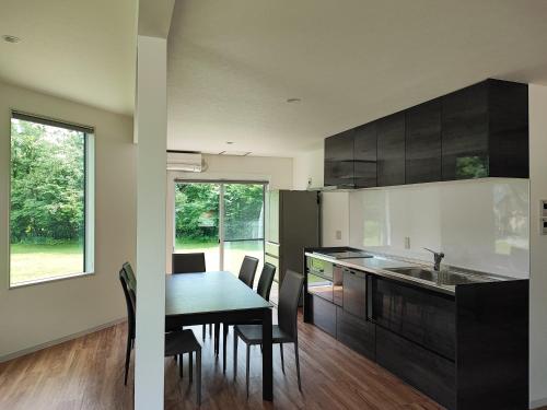 a kitchen with a table and a dining room at Hakuba Sunrise Apartments in Hakuba