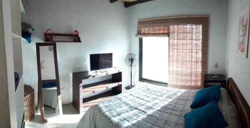 1 dormitorio con cama y ventana en La Armonie de Chacras en Chacras de Coria