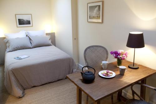 ein Schlafzimmer mit einem Bett und einem Tisch mit einem Obstteller in der Unterkunft Les Appartements d'Alexandre in Le Palais