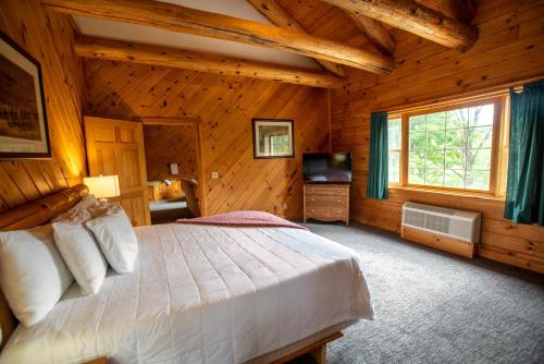 a bedroom with a bed in a log cabin at New England Inn & Lodge in North Conway