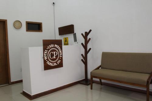 a room with a chair and a sign on a wall at Hotel Casa Peregrina in Tapalpa