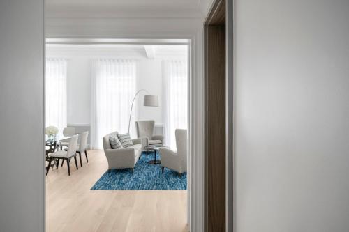 a living room with white furniture and a blue rug at COMO Metropolitan London in London