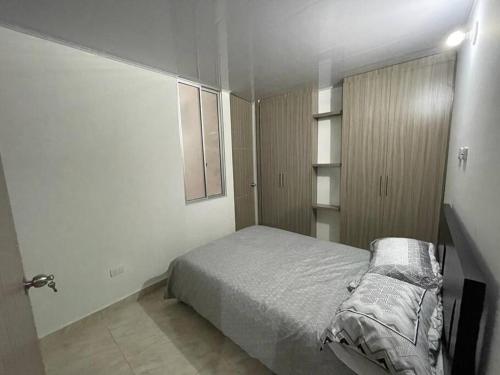 ein Schlafzimmer mit einem Bett in einem weißen Zimmer in der Unterkunft Hermoso apartamento completo 2 habitaciones - ubicación excelente para transporte al parque del café y PANACA in Armenia