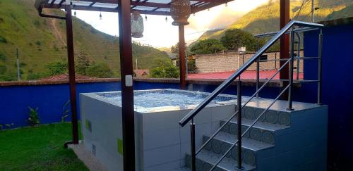 una casa con vasca immersione ad acqua fredda e montagne sullo sfondo di CASA VISTA HERMOSA a Baños