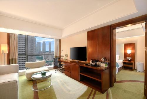 ein Hotelzimmer mit einem Bett und einem TV in der Unterkunft Holiday Inn Qingdao City Center, an IHG Hotel - May 4th Square in Qingdao