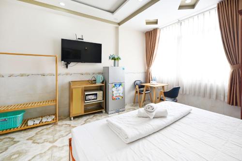 1 dormitorio con 1 cama, TV y mesa en Huyen House en Ho Chi Minh