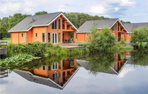 a row of houses on a river with reflections in the water at Lovely Home In Heel With House Sea View in Heel
