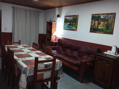 sala de estar con sofá, mesa y sillas en La Elegida con quincho y cochera en Esquel