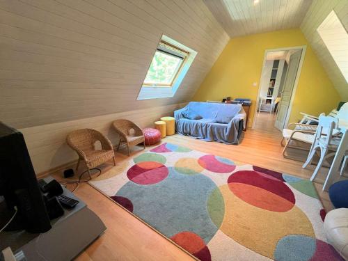 - un salon mansardé avec un grand tapis dans l'établissement Grande maison familiale à 800m de la plage de Kermor avec jardin - FR-1-481-122, à Combrit