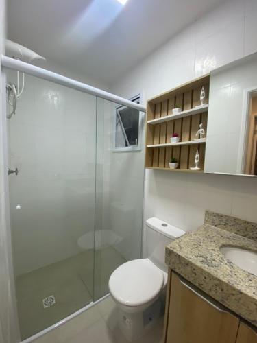 a bathroom with a shower and a toilet and a sink at Apartamento em Bertioga com varanda gourmet in Bertioga