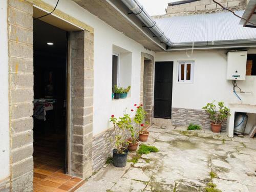 an open door of a white house with potted plants at Xelanos in Quetzaltenango