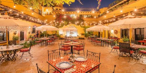 an empty restaurant with tables and chairs and lights at Hacienda El Santuario San Miguel de Allende in San Miguel de Allende