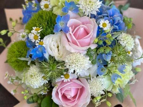 a bouquet of pink roses and blue flowers at Kappo Ryokan Yumesaki in Beppu